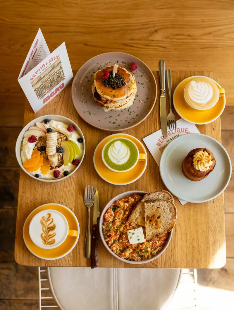 Table de brunch vue du dessus : pancakes, matcha, bowls et lattes